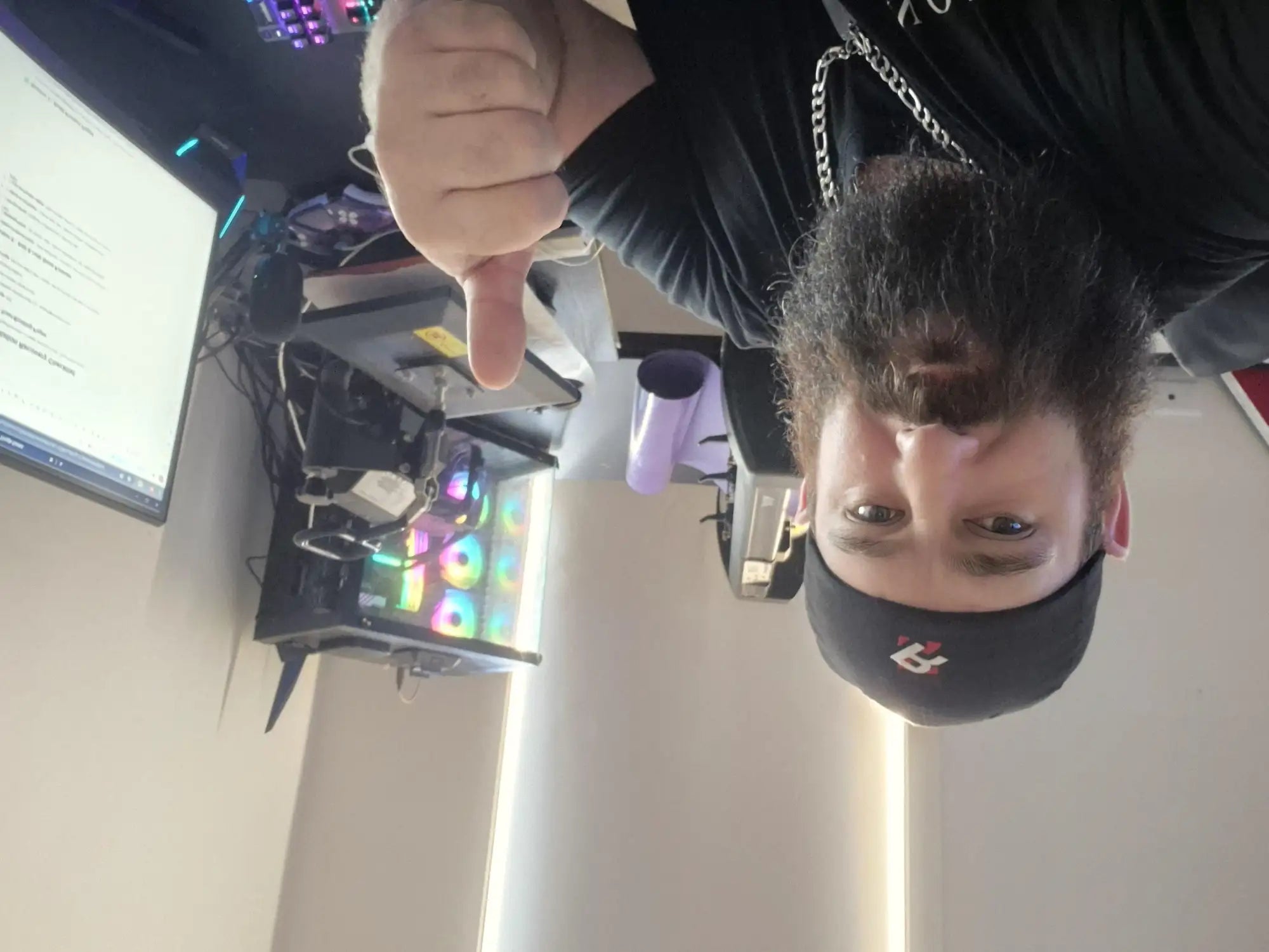 Person with a computer case open showing RGB lighting, giving a thumbs-up.