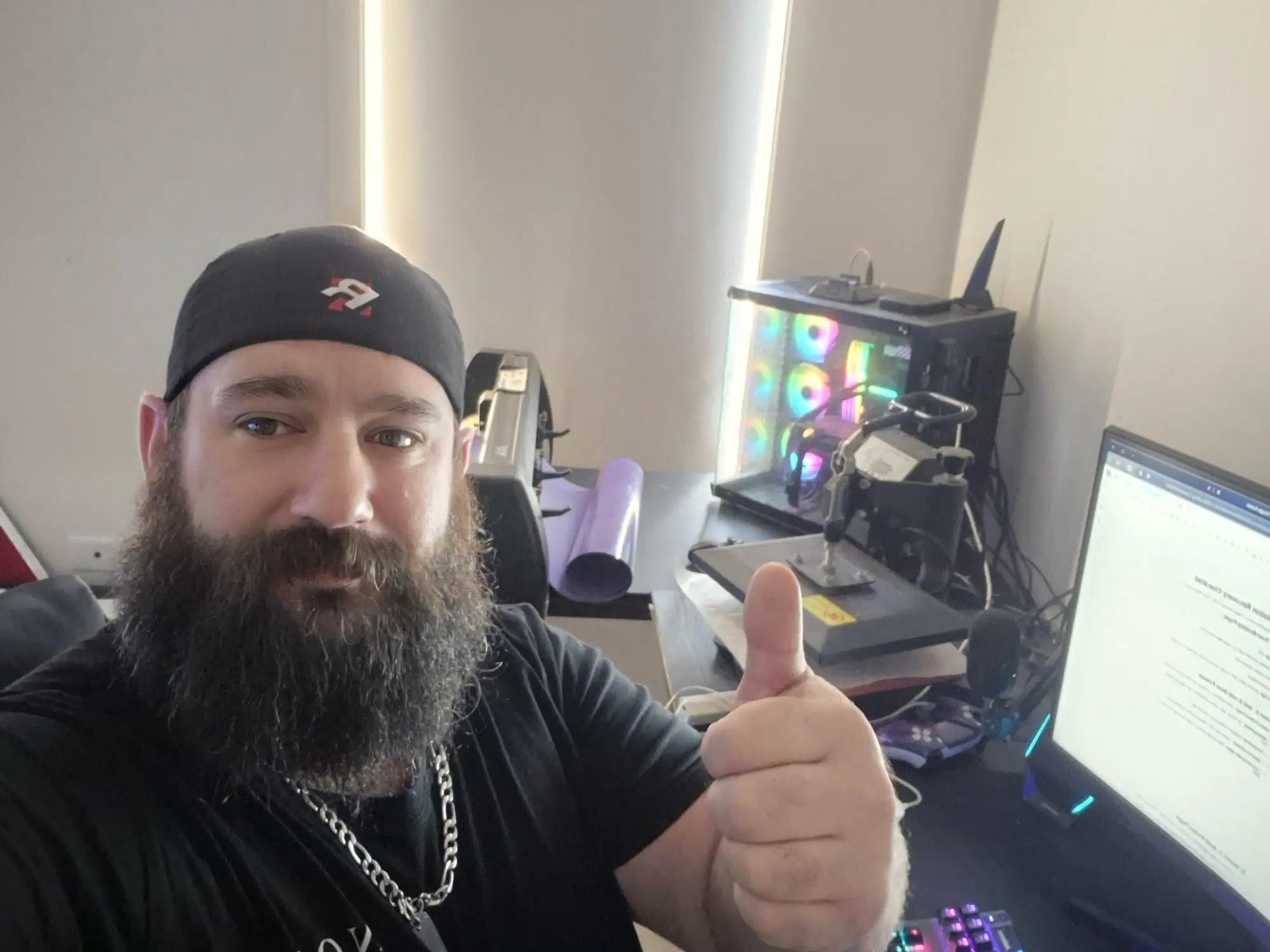 Black baseball cap with white logo and chain detail.