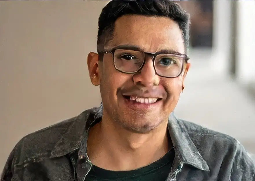 Brown leather jacket with black buttons and zipper, worn over a gray t-shirt.